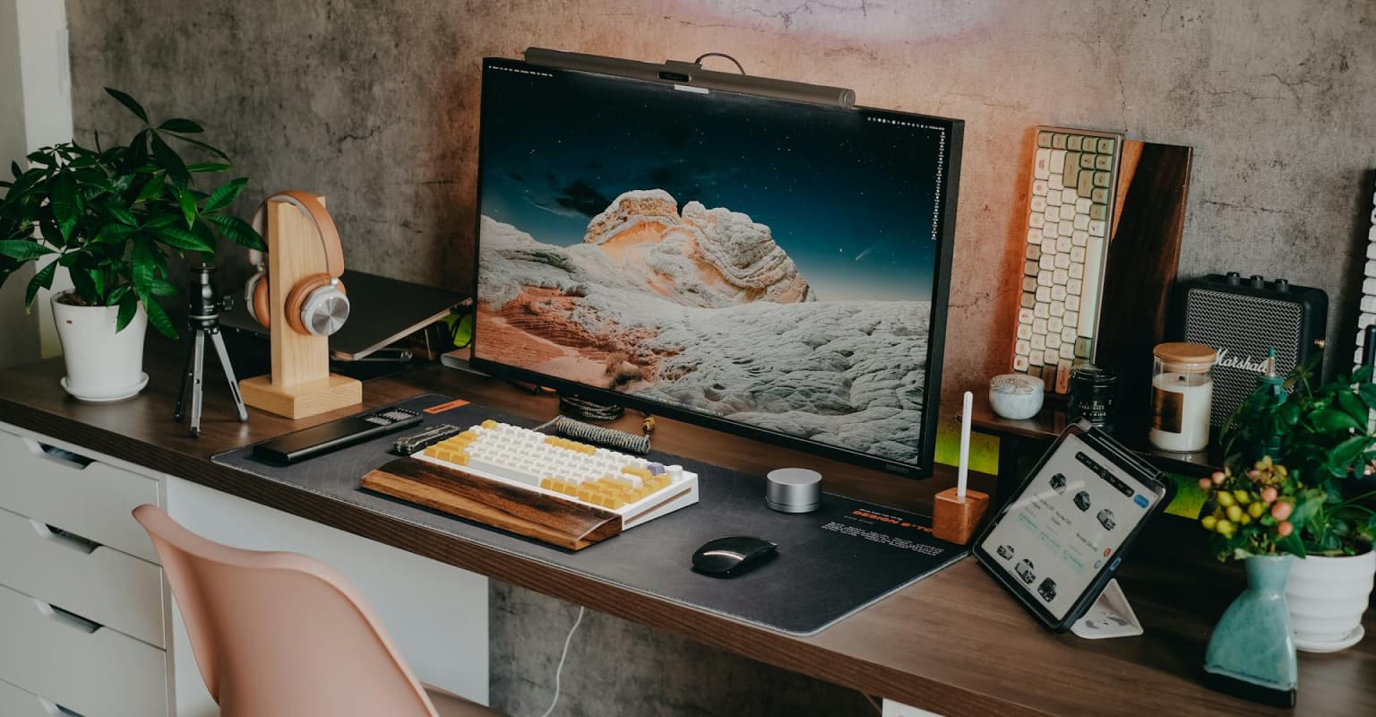 beautiful desk setup with dark woods and concrete walls
